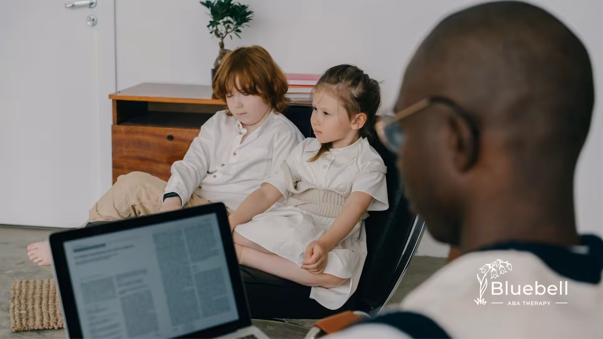 Two children with autism sit attentively during ABA therapy session with an RBT in North Carolina.