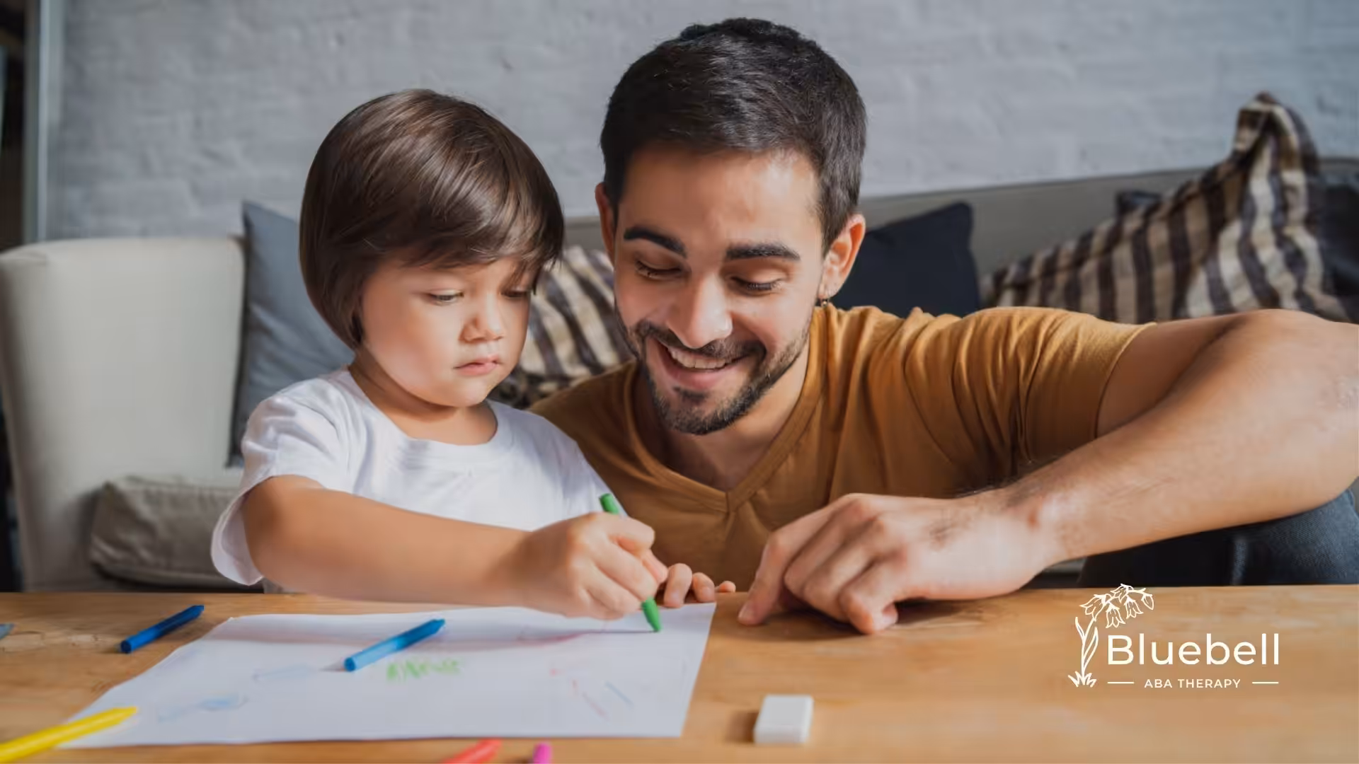 ABA therapist supporting young child in a drawing activity.