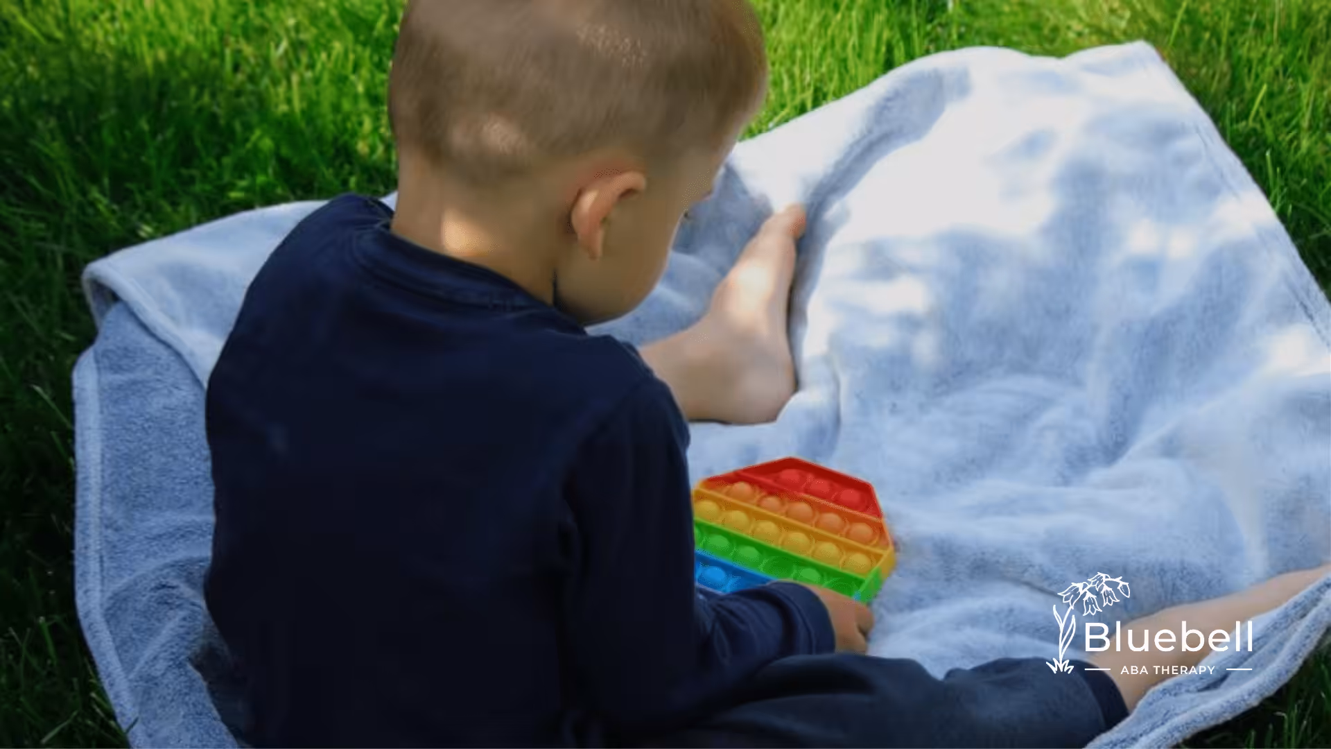 A little boy playing with a fidget toy.