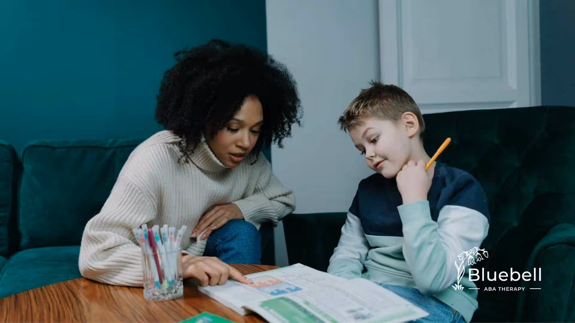 An ABA therapist helping an autistic boy with reading and homework at a cozy home in North Carolina.