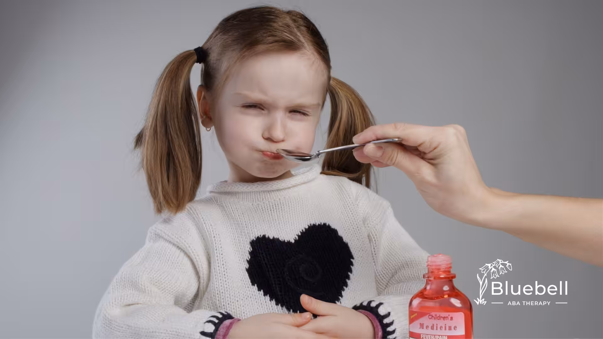 A little girl getting her medicine.