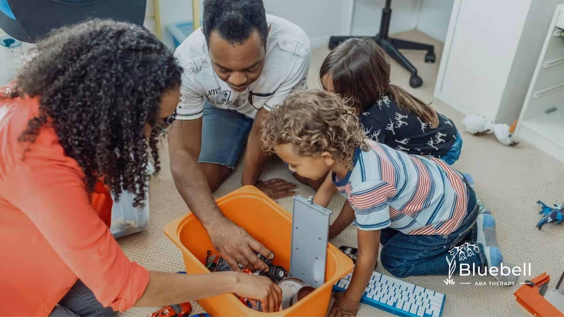 A family with autistic kids gathering around a toy box, engaging in an interactive activity in NC.
