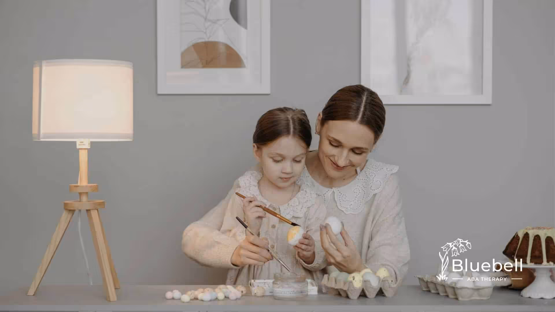 An RBT and autistic girl painting eggs together at a table during in-home ABA therapy in NC.