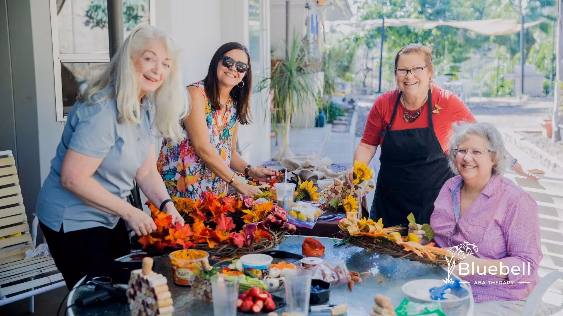 A group of women socializing while doing flower arrangement