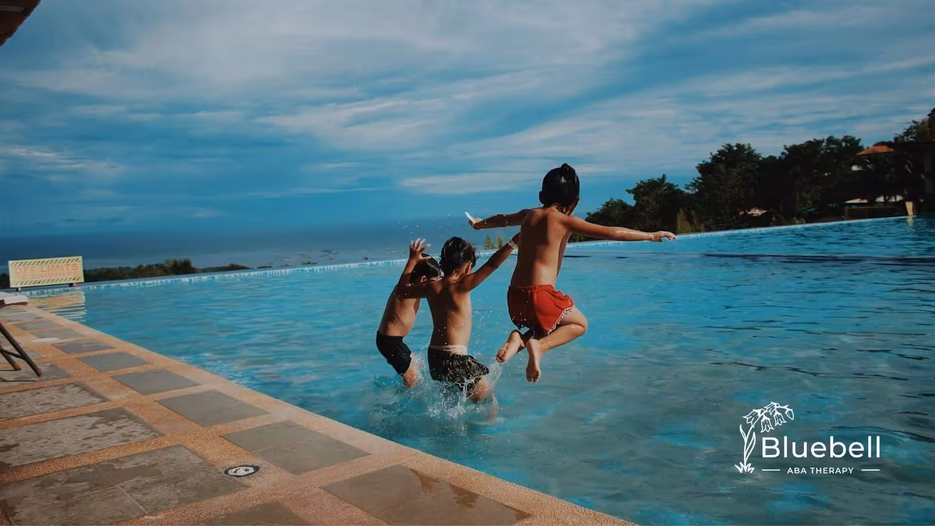 Three autistic kids excitedly jumping into a swimming pool on a sunny day in North Carolina.