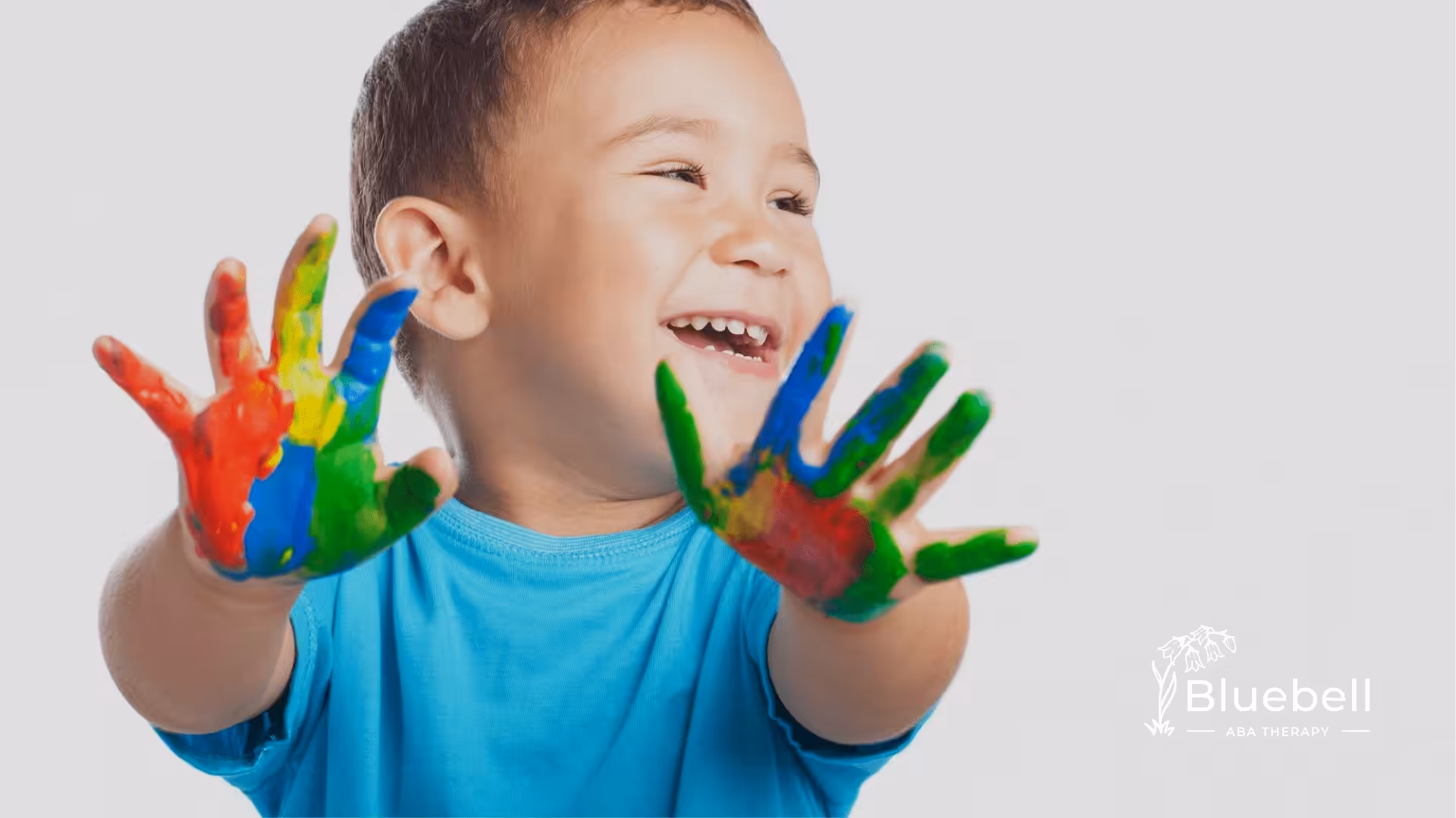 A boy holding his hands up colored with paint