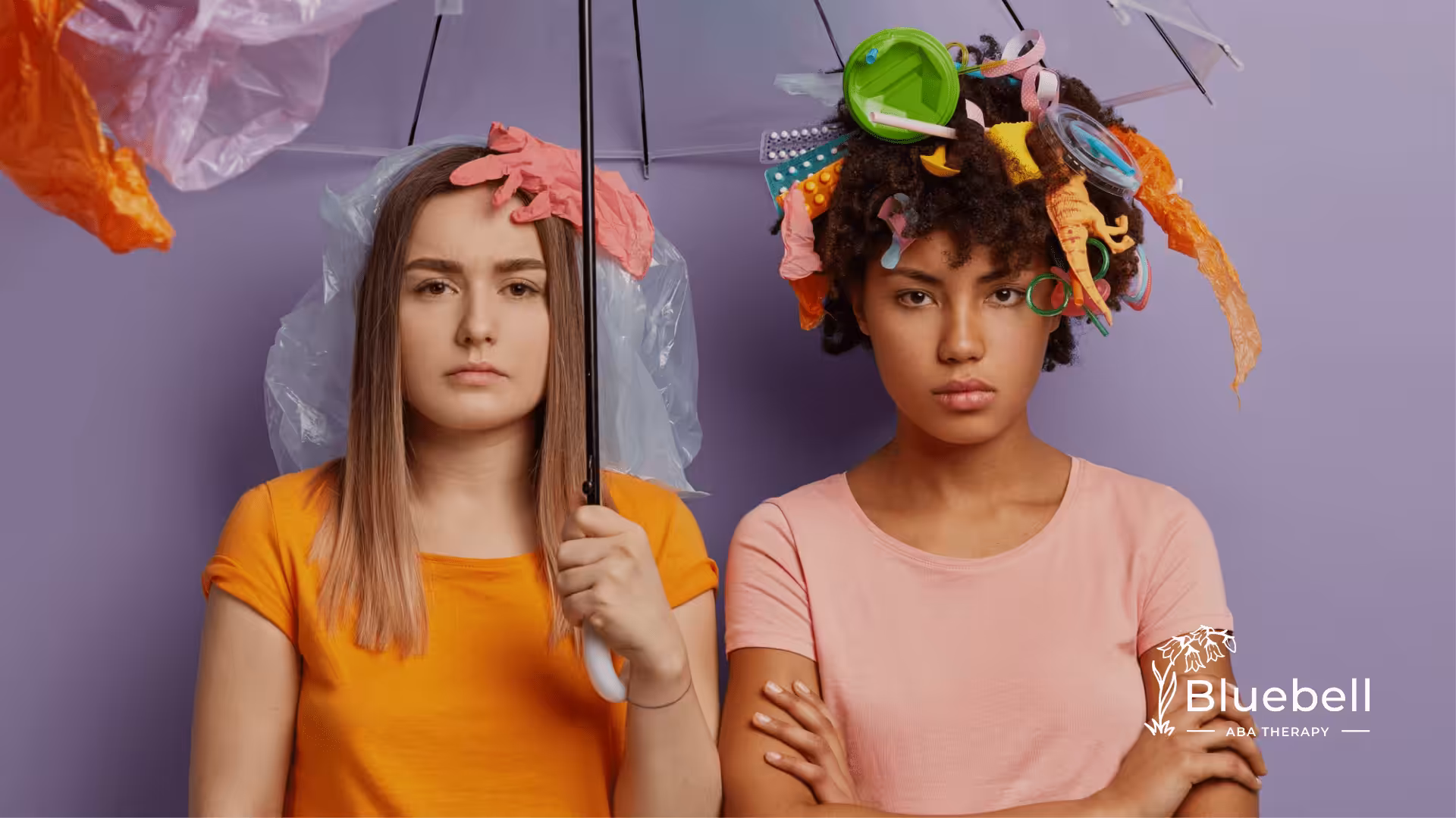 Two adults with autism under an umbrella with colorful cutouts of paper on their hair