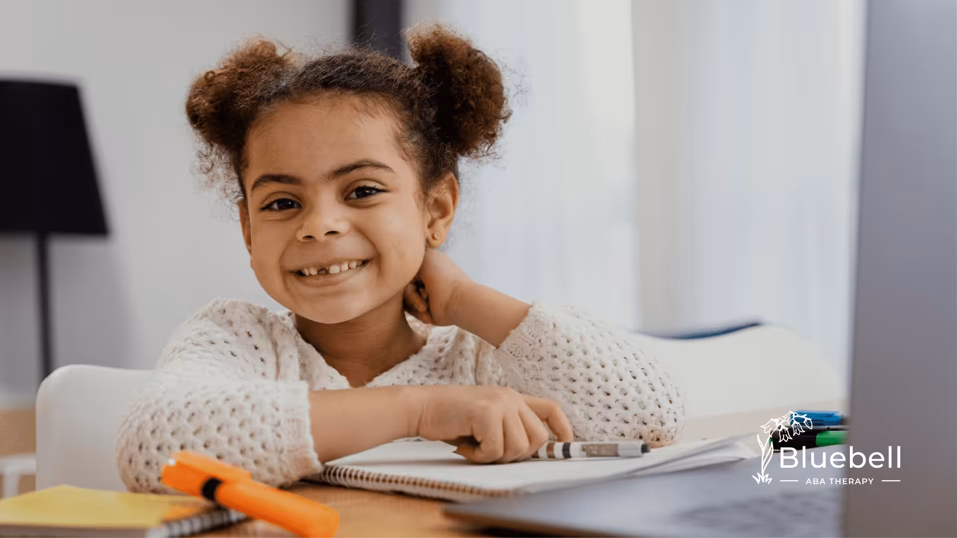 A girl with autism is sitting on a table with her homework