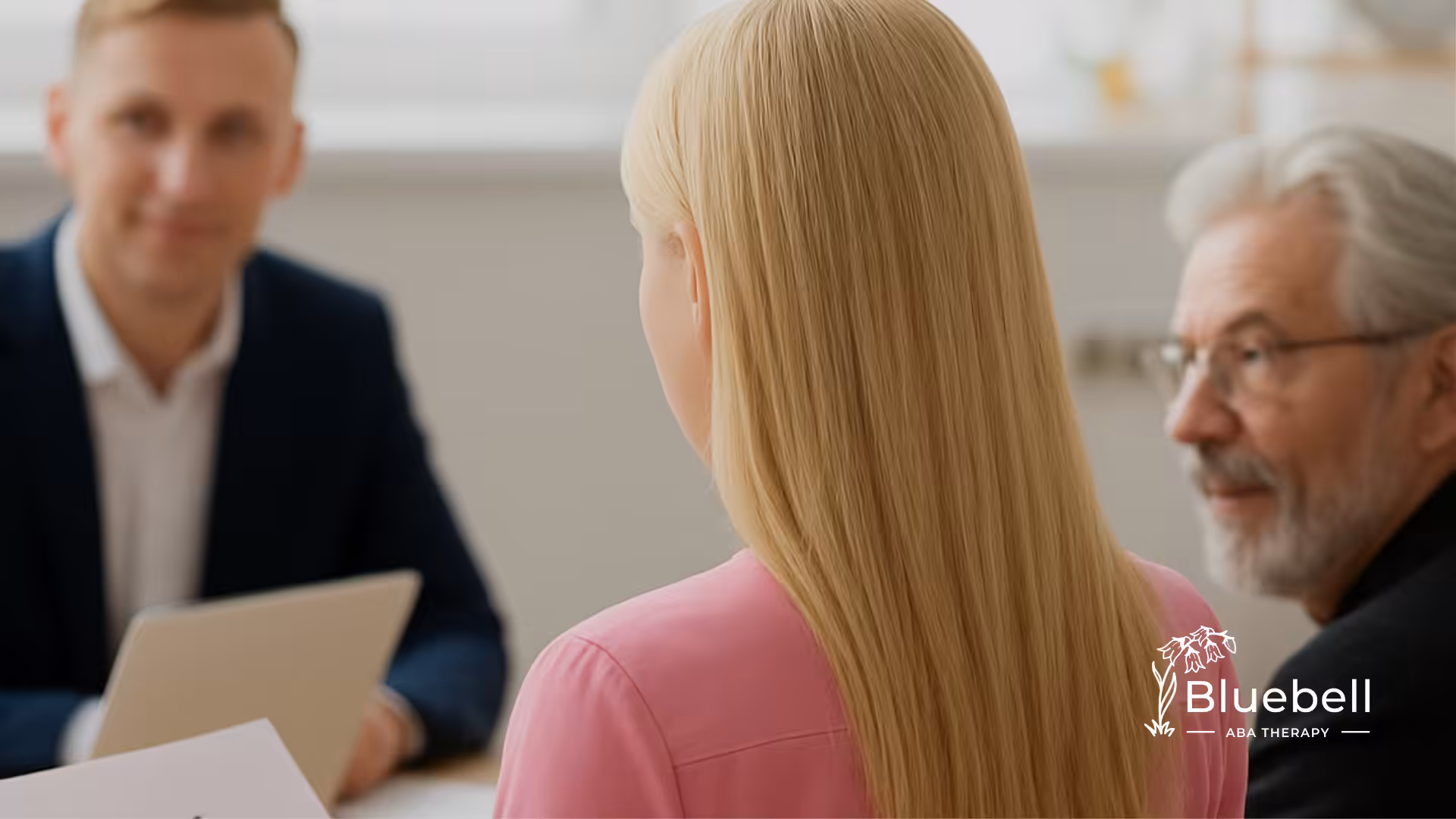 A blonde lawyer wearing a pink coat is talking to her co-lawyers