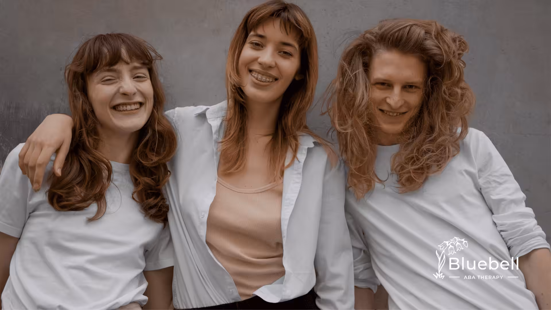 Three women with autism standing next to each other smiling for a photo