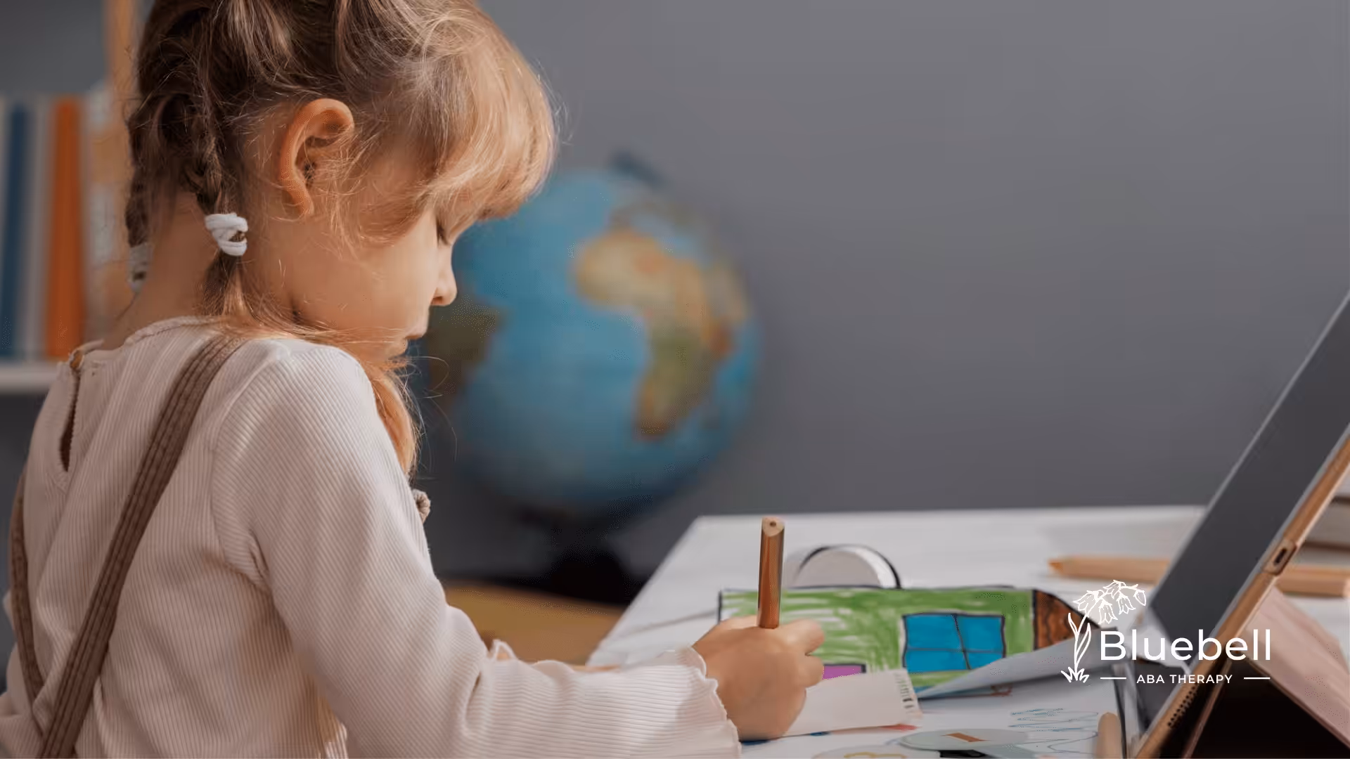 A child with autism is drawing in a piece of paper