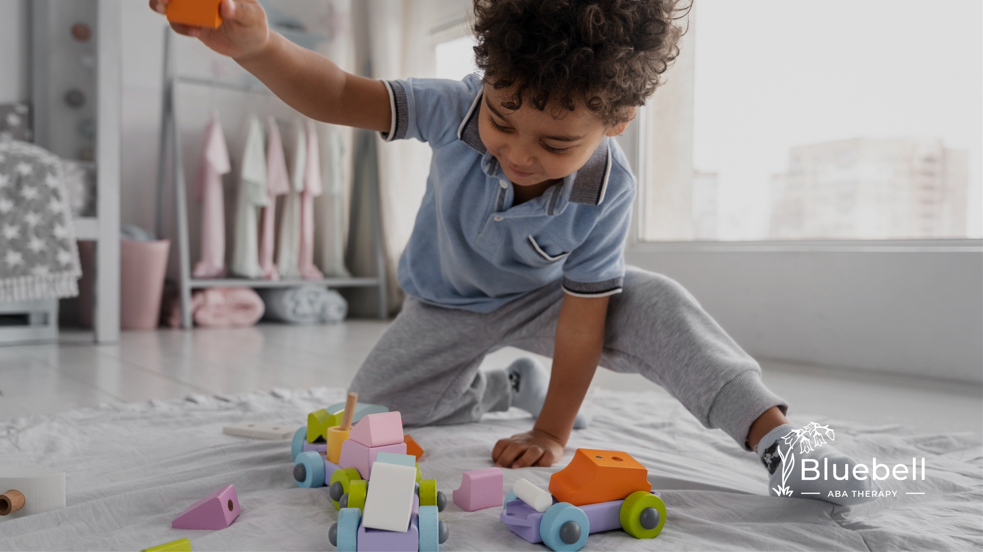A kid with autism playing with colorful toys on a carpet in a bedroom