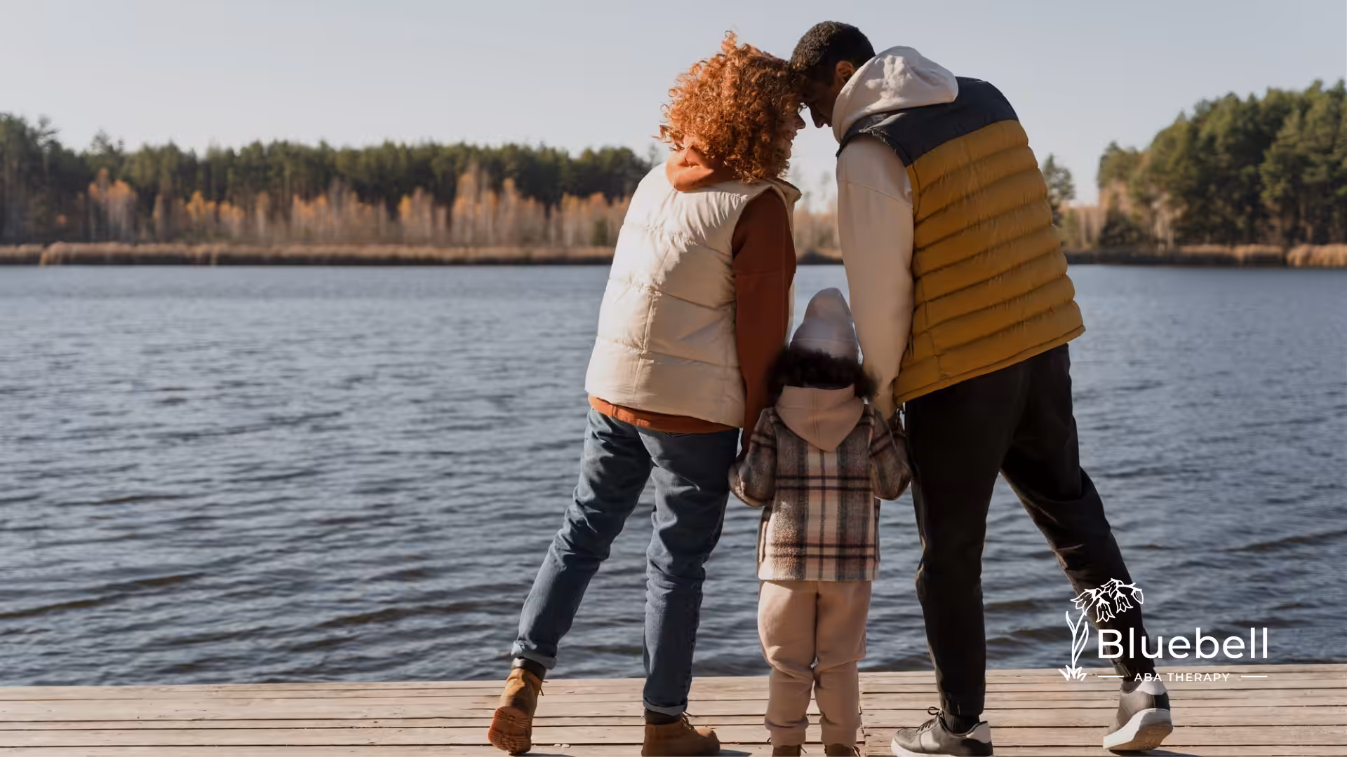 A family of three standing together in a seashore