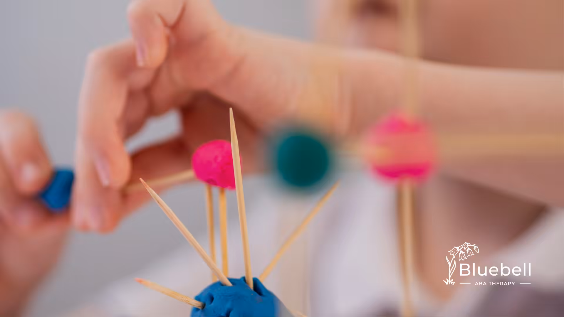 A kid with autism is making a craft out of clay and toothpicks