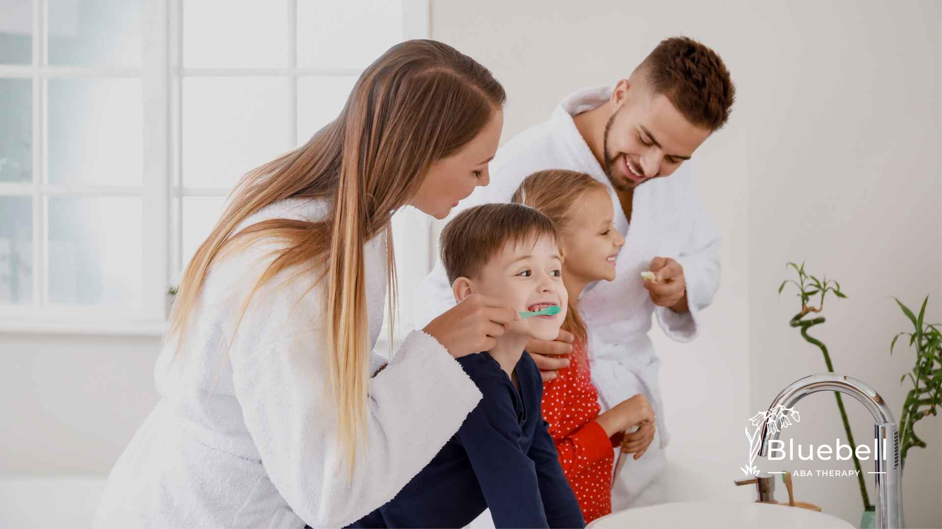 A family of four, wearing white robes, happily brushes their teeth in a bright bathroom. The atmosphere is cheerful and cozy.