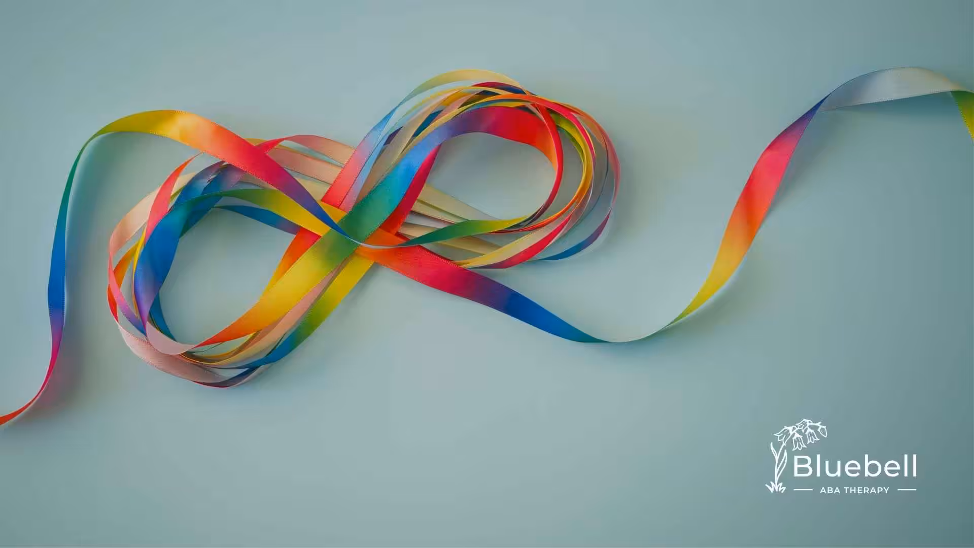 A colorful ribbon loops on a light blue background, forming an infinity symbol. The mood is vibrant and dynamic.