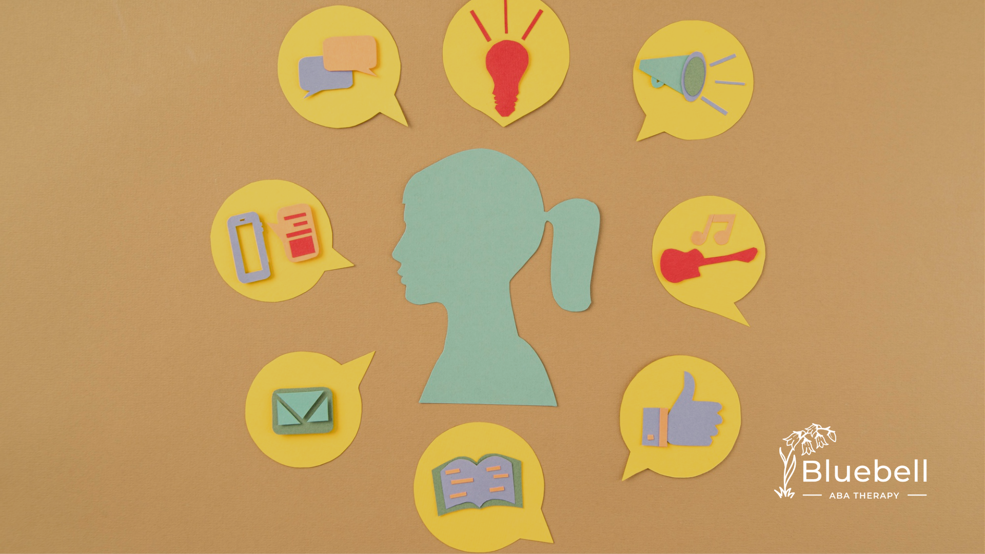 A paper cutout of a girl's head with cutouts of icons around it