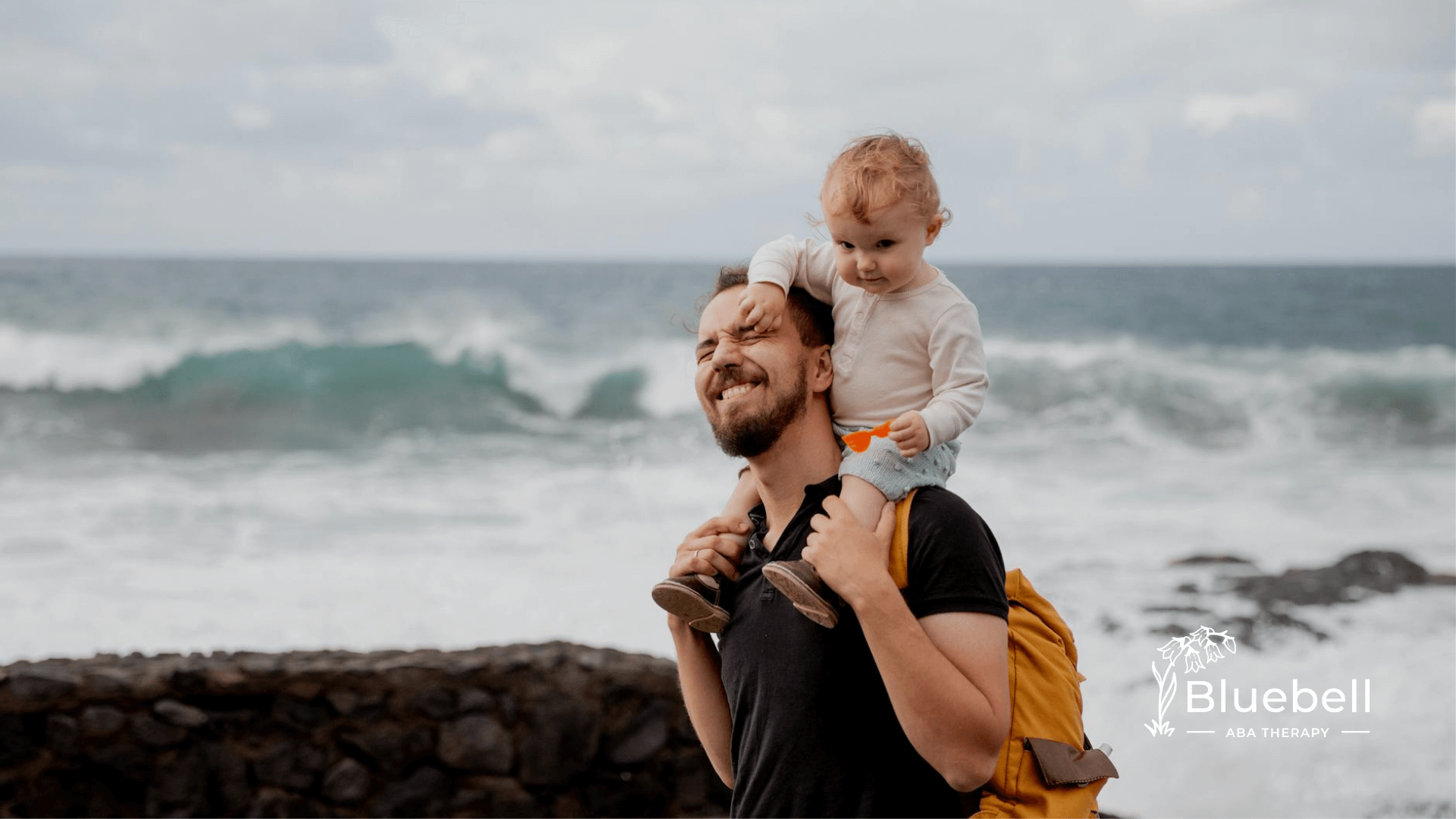Autistic father carrying his autistic child on his shoulders on the beach after ABA therapy in North Carolina.