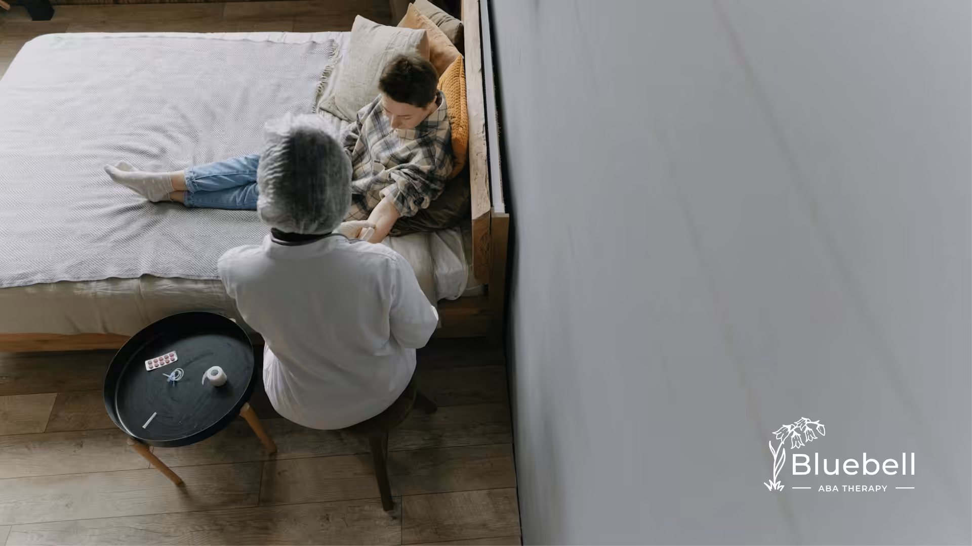 Medical professional attends to young patient in bed after the ABA therapy, offering calm and focused care.