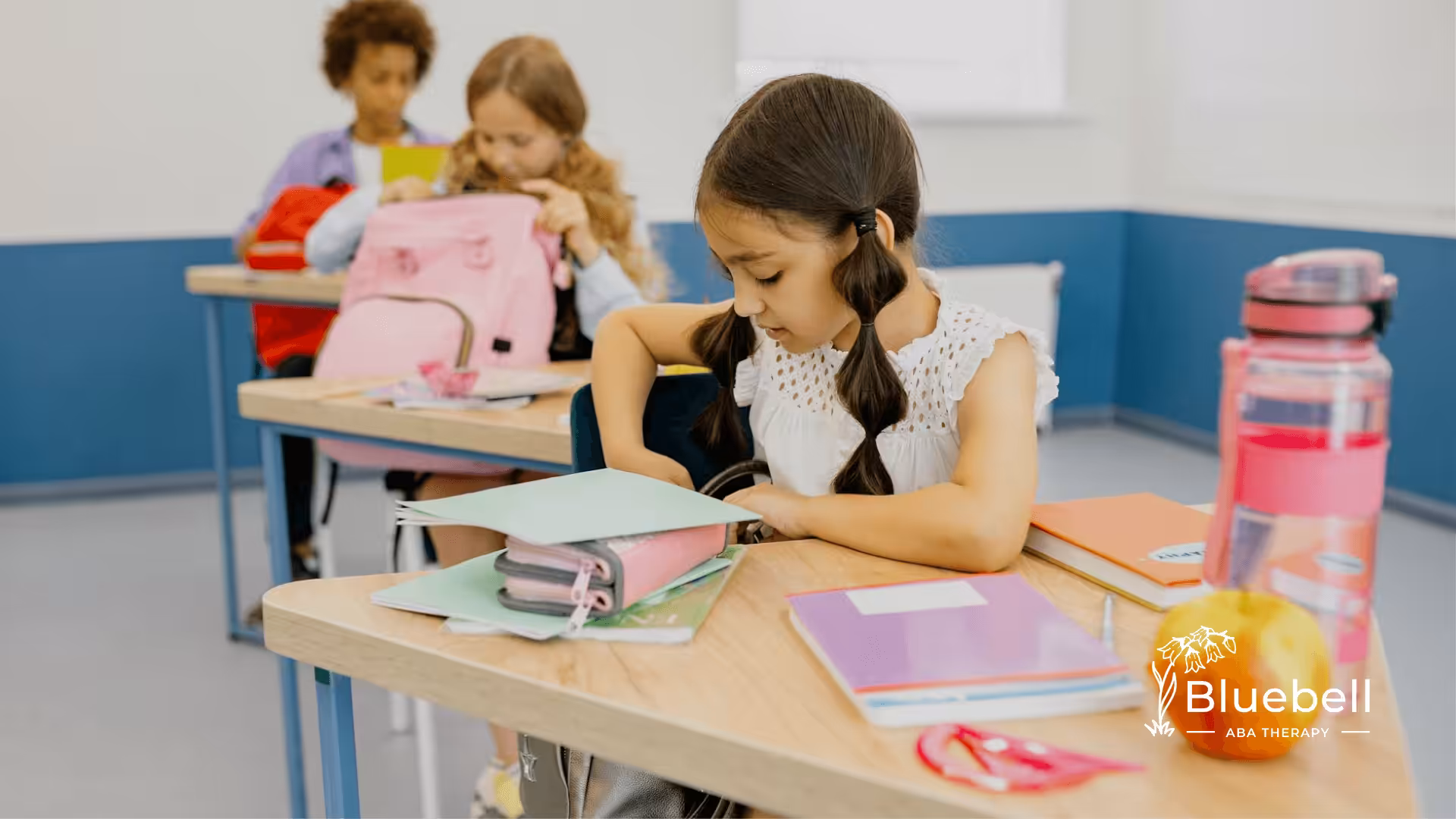 Autistic young girl organizing school supplies in the classroom after ABA therapy in North Carolina.