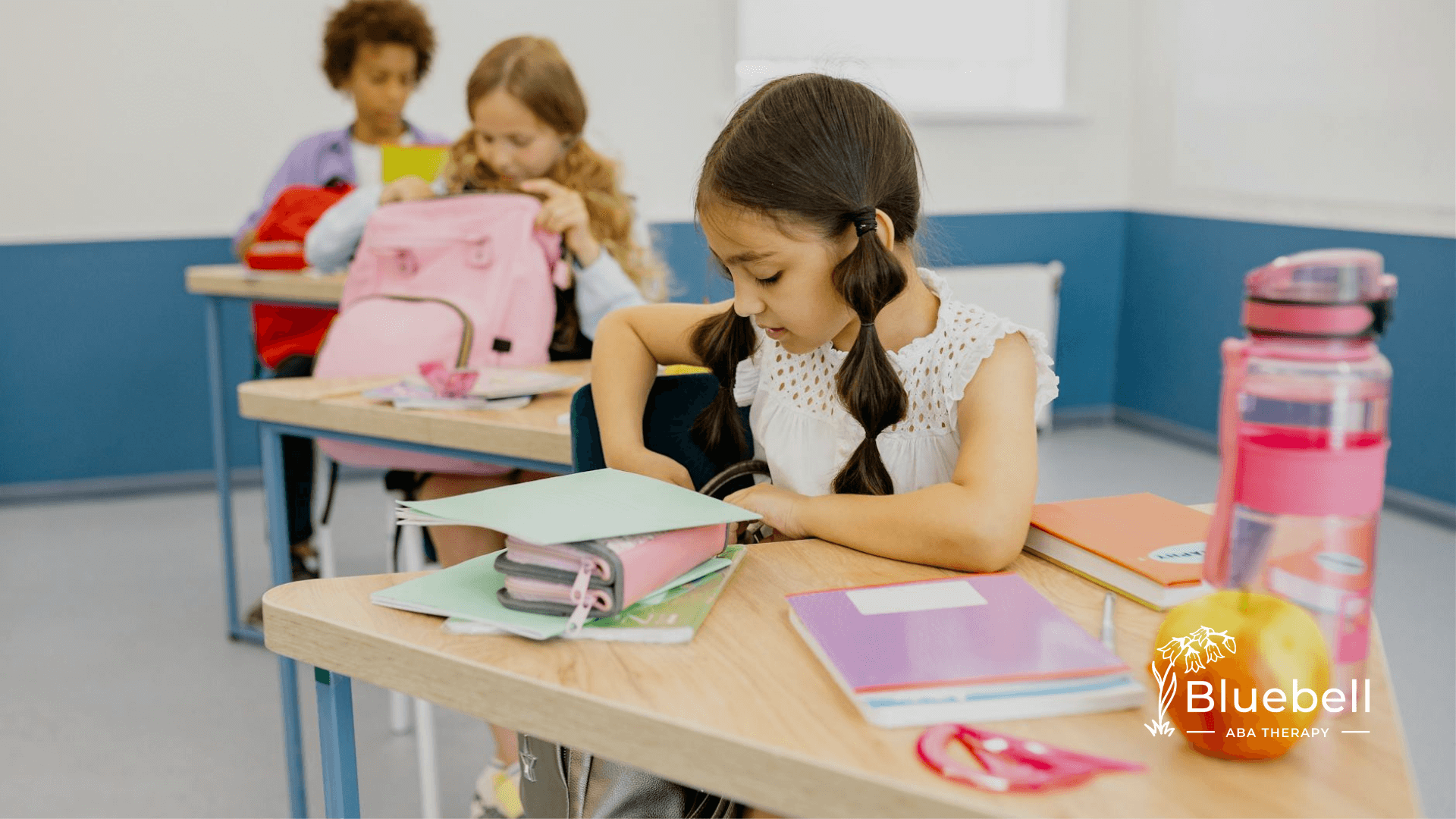 Autistic young girl organizing school supplies in the classroom after ABA therapy in North Carolina.
