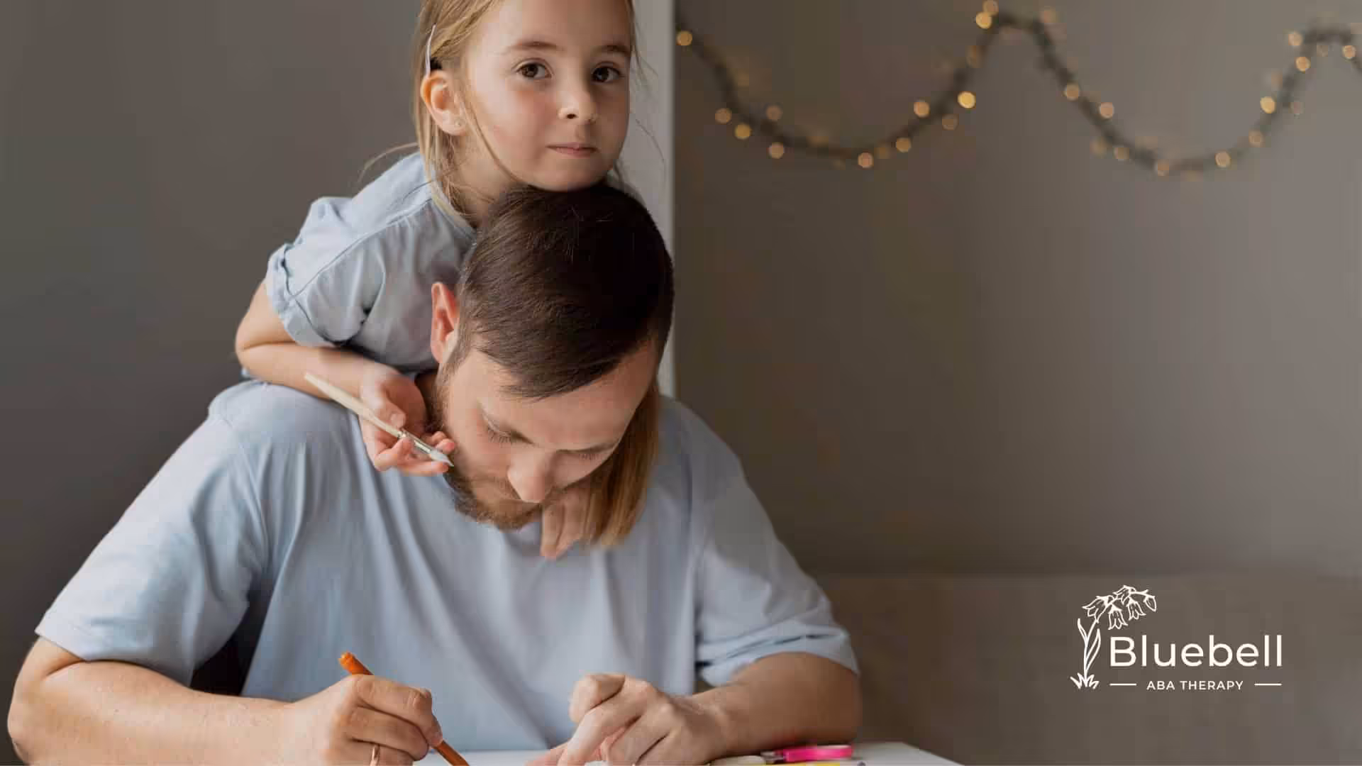 An autistic kid sitting on a therapist's shoulders while drawing, illustrating close bonding and shared activities.