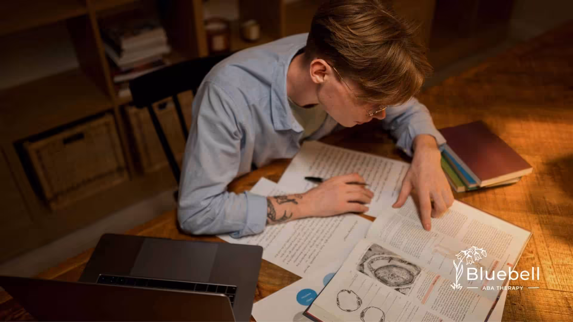 ABA student studying late at a desk with open textbooks and laptop, highlighting focus, preparation, and academic commitment.