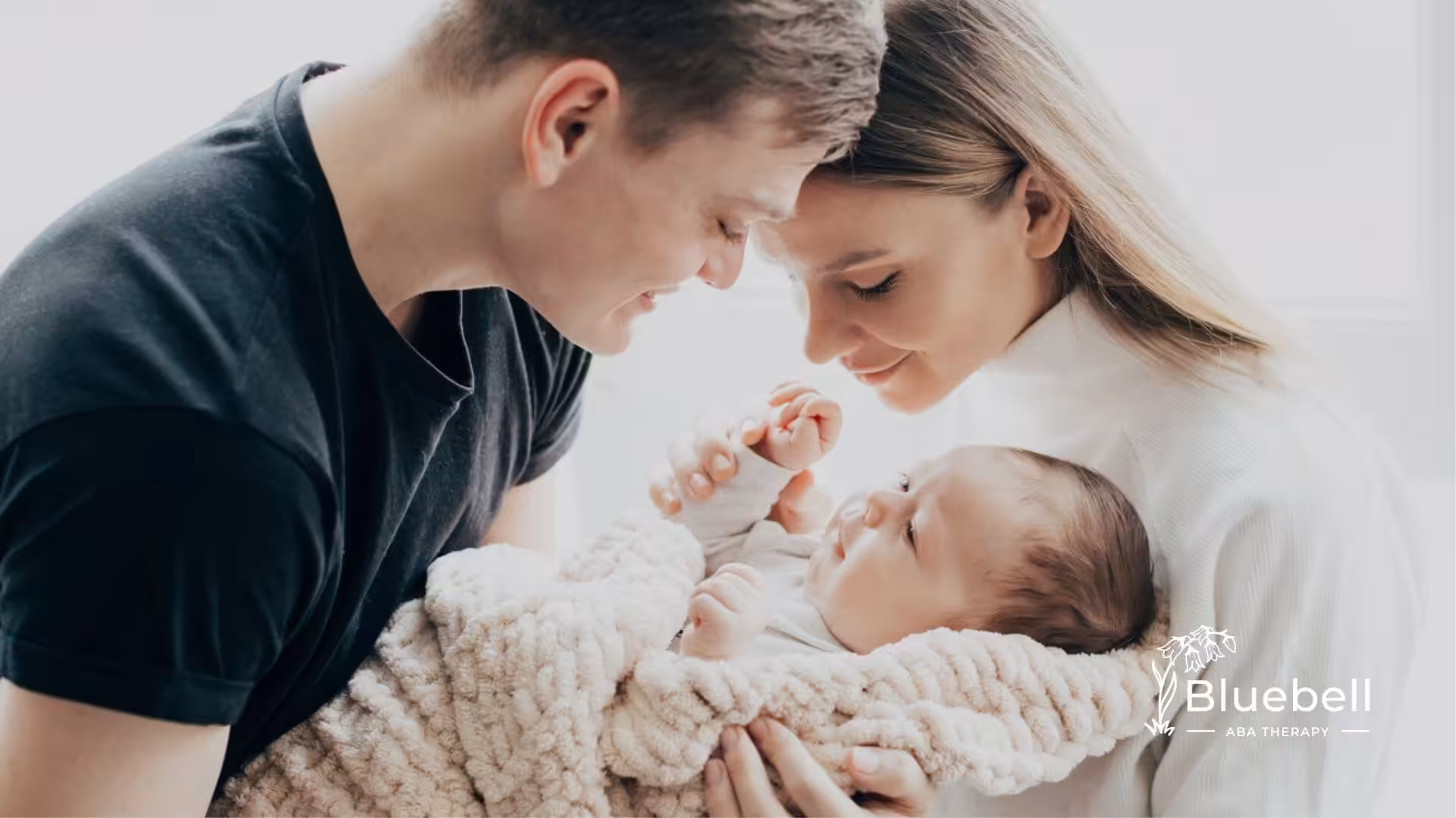 Parents holding and looking at their newborn baby.