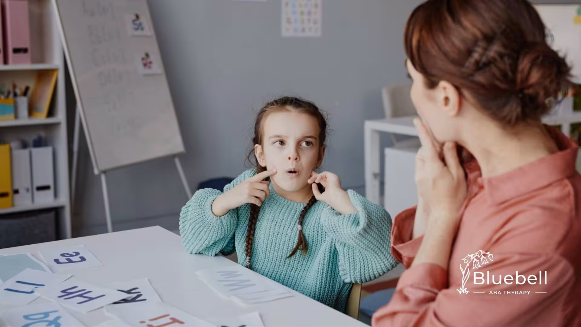 Young child practicing speech sounds with a BCBA during ABA therapy.