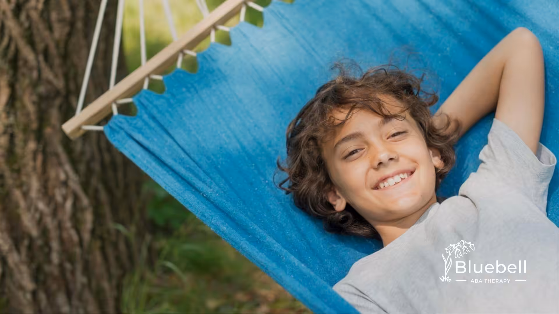 Child with autism relaxing in hammock outdoors smiling