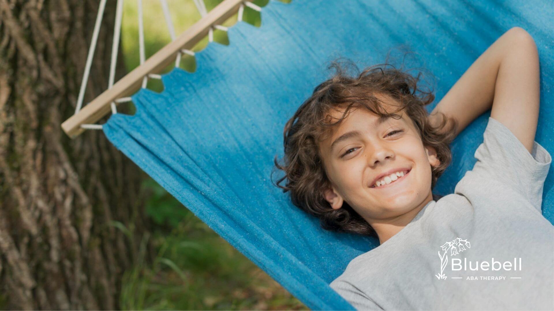 Child with autism relaxing in hammock outdoors smiling