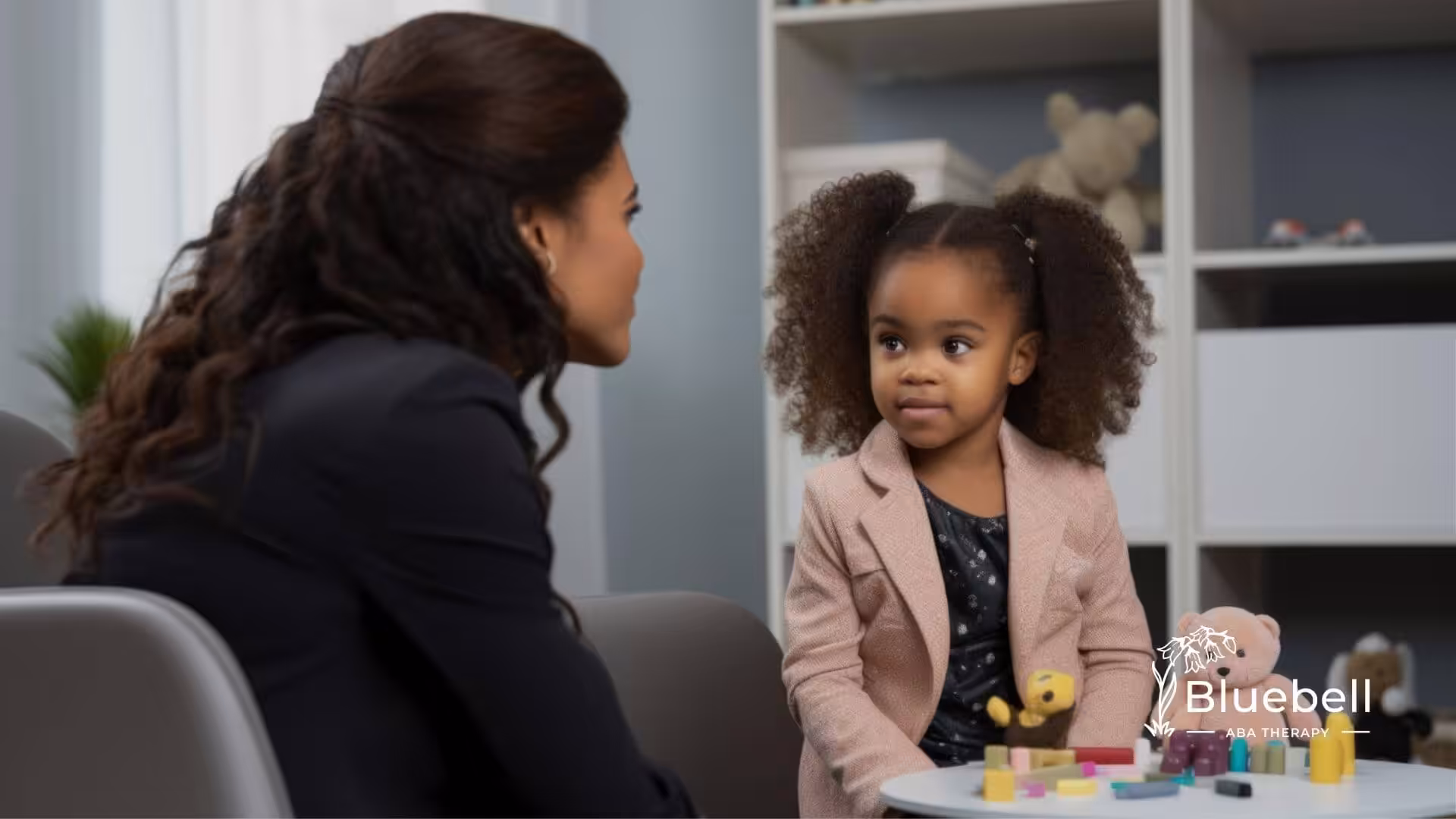 ABA therapist engaging young child during structured play session.